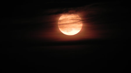 Full moon with some clouds passing in front of her.