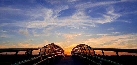 The bridge over the river at sunset. Beautiful sky with clouds.の写真素材