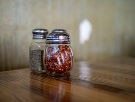Red pepper and salt condiments on table