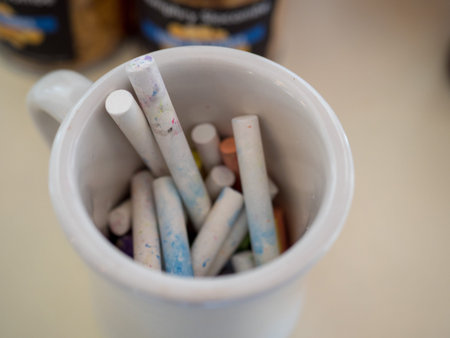 Close up of pile of white chalk in a cup ready to use on blackboard