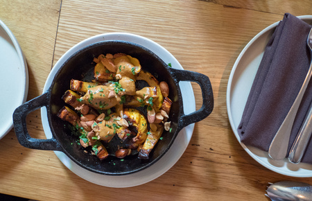Grilled squash dish in small cast iron skillet next to napkins and plateの写真素材