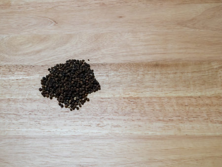 Overhead shot of neat pile of peppercorn on wooden block