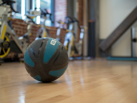 Medicine ball in an exercise studio with equpiment and bikes in background with space to the rightの写真素材