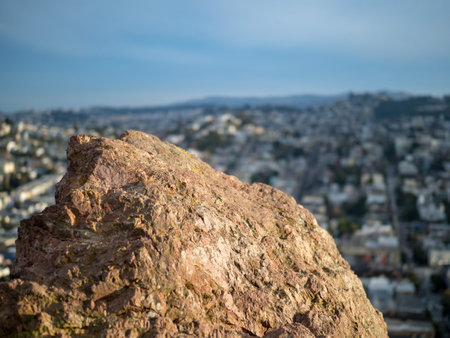Rock at the top of a park with city in background (San Francisco)