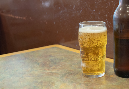 Beer mug and large beer bottle to side with space to leftの写真素材