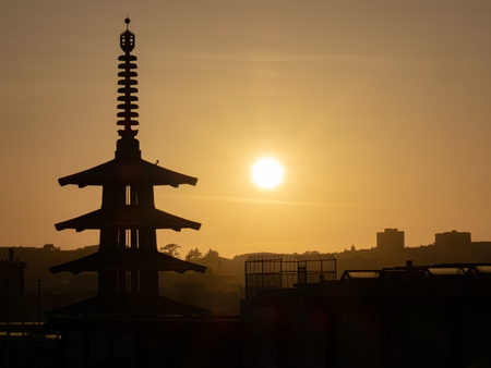 Silhouette of Peace Pagoda and city of San Francisco, CA while sun is setting to rightの写真素材