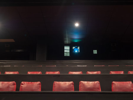 Movie theater film projector playing ove head in an empty theaterの写真素材