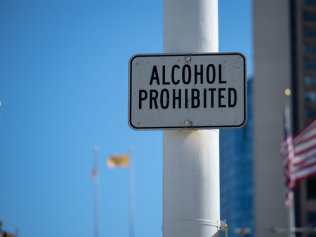 Alcohol prohibited sign hanging high in an urban area outdoors in a sunny area