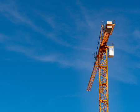 Crane high in view amidst sunny day outside in a sunny areaの写真素材