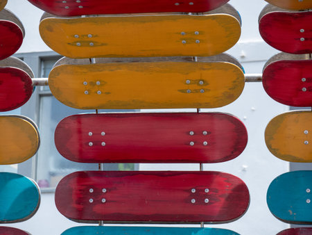A number of red and orange skateboard decks mounted on a structureの写真素材