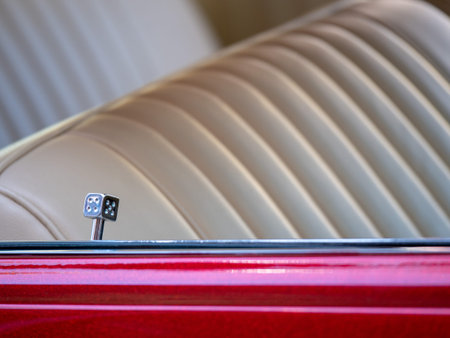 A decorative, novelty dice car door lock on a lowrider with leather seats