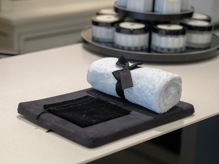 Designer fashion accessories of bow wrapped towel and bag waitinの写真素材