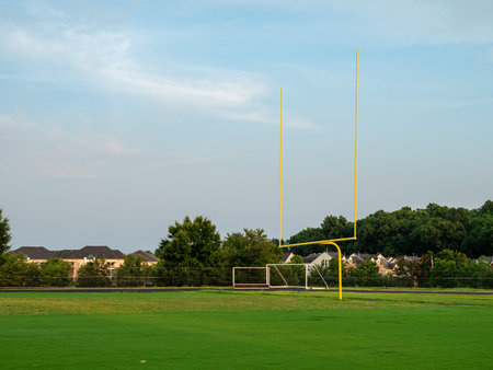 Football goal post at a high school field in the evening sun