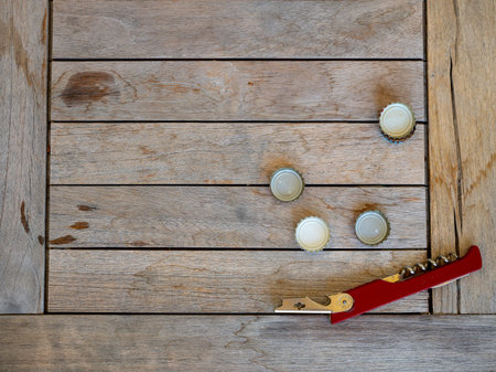 Beer bottle caps and bottle opener sitting on wooden table outdoors at party event