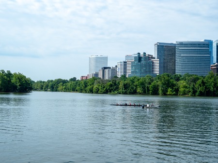 Rowers practice on the Potomac River with office buildings in Arlington, VA in backgroundのeditorial素材