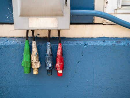 Red, white, blue, and red industrial power cables suspendedの写真素材