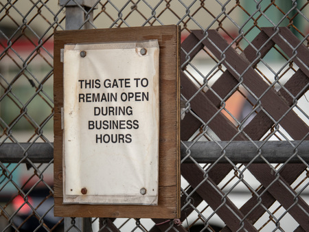 This gate to remain open during business hours paper sign on fenceの写真素材