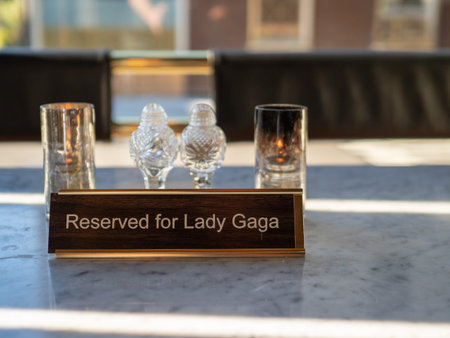 Reserved for Lady Gaga sign sitting on marble restaurant table with candles with salt and pepper...