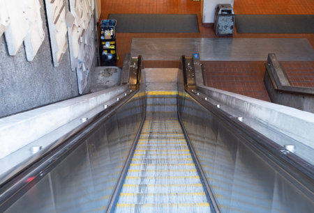 Escalator leading down into a subway tunnel in the daytime