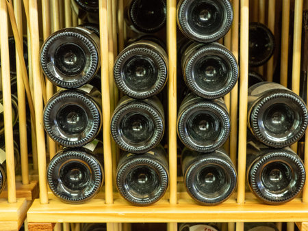 Bottles of red wine in wine rack with ends facing out in store