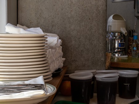 Plates, utensils, napkins, drink mix materials behind barの写真素材
