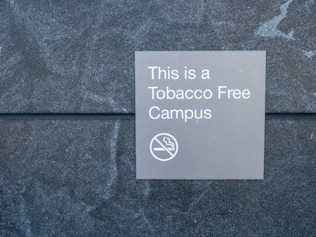 This is a tobacco free campus gray sign and logo posted outside of buildingの写真素材