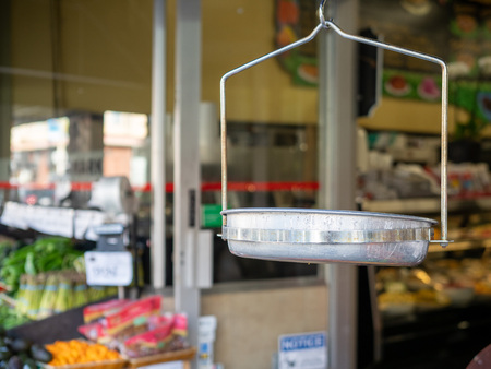 Hanging steel grocery scale at the entrance of a supermarket with produceの写真素材