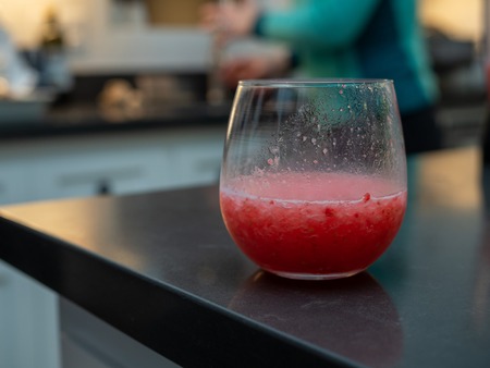 Close up of a grapefruit margarita in the middle of consumption on a home kitchen countertopの写真素材