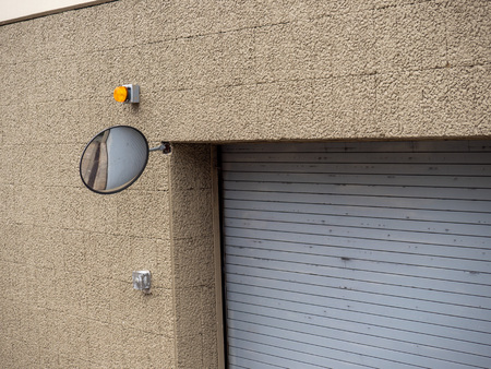 Safety mirror on corner of parking garage complex building entranceの写真素材
