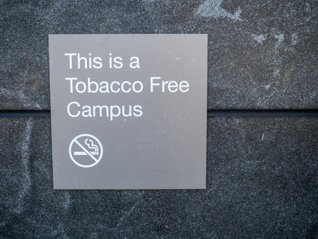 This is a tobacco free campus sign and logo posted outside of buildingの写真素材