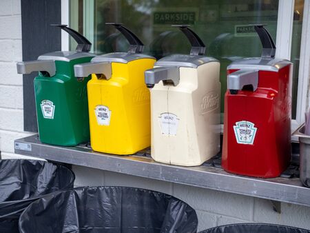 Large commercial dispensers of Heinz ketchup, mustard, relish, and mayonnaise outside for hot dogs and hamburgersのeditorial素材