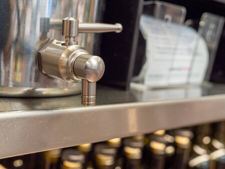 Steel beverage dispenser handle in closed position sitting on shelfの写真素材