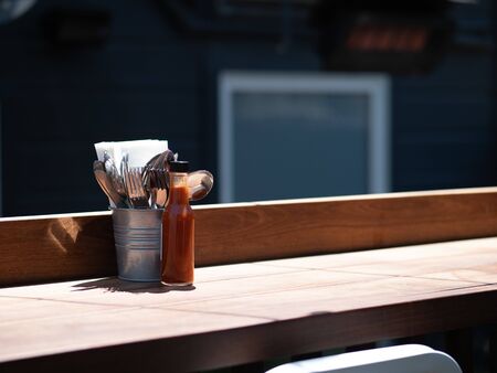 Utensils and hot sauce in prep for dining service at outdoor restaurantの写真素材