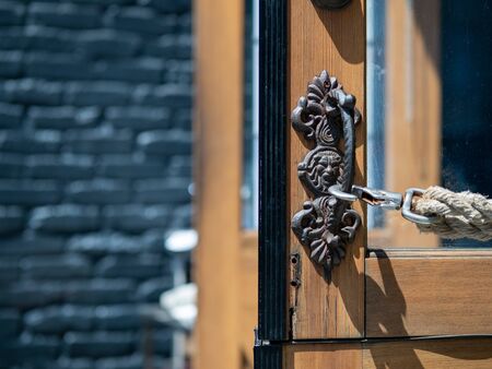 Intricate door handle to entrance with rope holding door openの写真素材