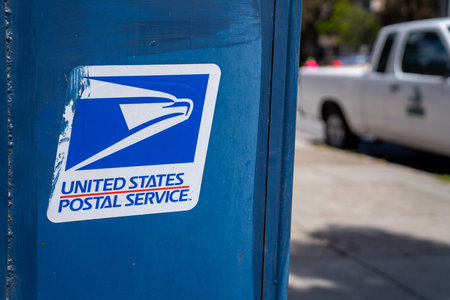 United States Postal Service USPS, logo and on mail box on sidewalk