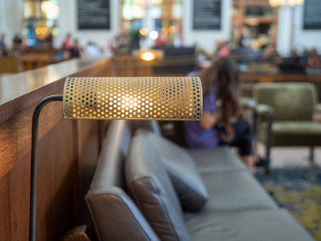 Desk lamp at table of train station with woman traveler waiting on chair