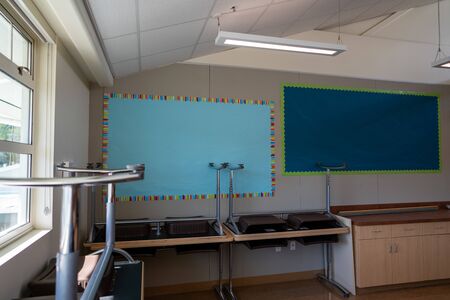 Corner of empty classroom with tables and blank posters before the school yearの写真素材