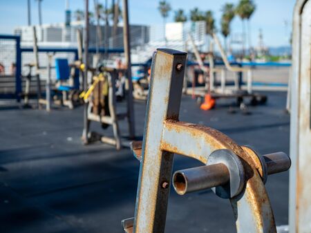 Rusted outdoor weight rack empty at public gym with workout equipment in backgroundの写真素材