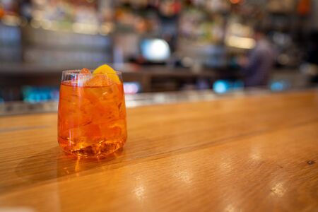 Full orange spritz cocktail drink sitting on bar counterの写真素材