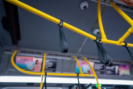 Suspended safety rail wrist straps on a public transportation busの写真素材