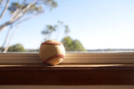 Old baseball sitting on a window sillの写真素材