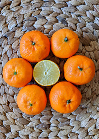 Ibiza, Islas Baleares, Spain - January 14, 2021: Tangerines (oranges, mandarins, clementines, citrus fruits) with leaves in open basket over gray backgroundの写真素材