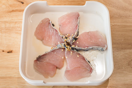 Sukiyaki, Hot Pot, shabu Fresh peeled sea bass fish fillet isolated in a white small dish on wood table background of Hot Pot Ingredients.の写真素材