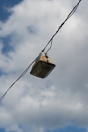 A street lamp hanging on a cable wiringの写真素材