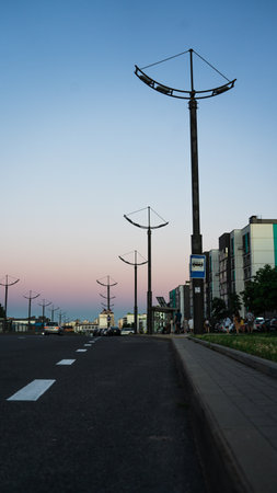 Street lamp poles, road, sunset skyの写真素材