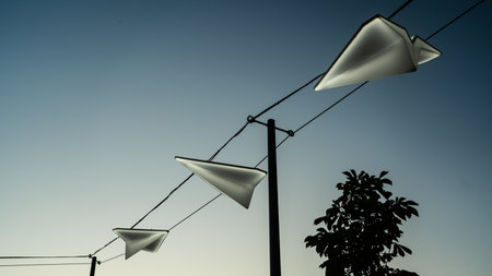 Street lights in the form of paper airplanes, against the background of the sunset skyの写真素材