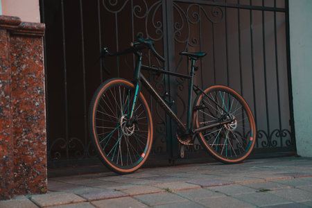 A sports bike strapped to a wrought-iron gateの写真素材