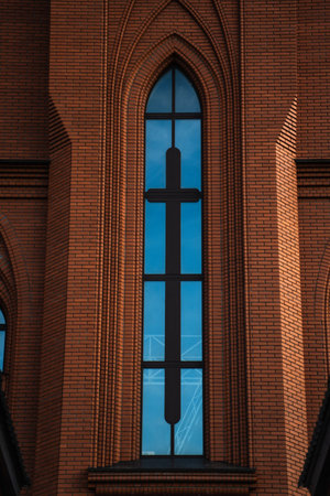 The high, narrow window of the church. The red brick masonry of the churchの写真素材