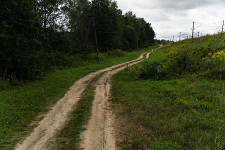 A rural, dirt road leading up. Cloudy skyの写真素材