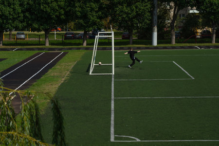 The schoolboy football player missed a goal. The school stadium. Football gatesの写真素材